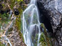 Dünne Wasserfallfäden über bemoostem Fels der Silberkar Klammwand